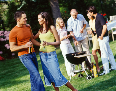 Junge Leute grillen bei einer Gartenparty